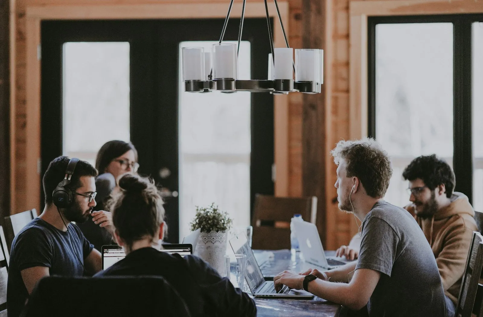 Equipe reunida trabalhando com notebooks ao redor de uma mesa